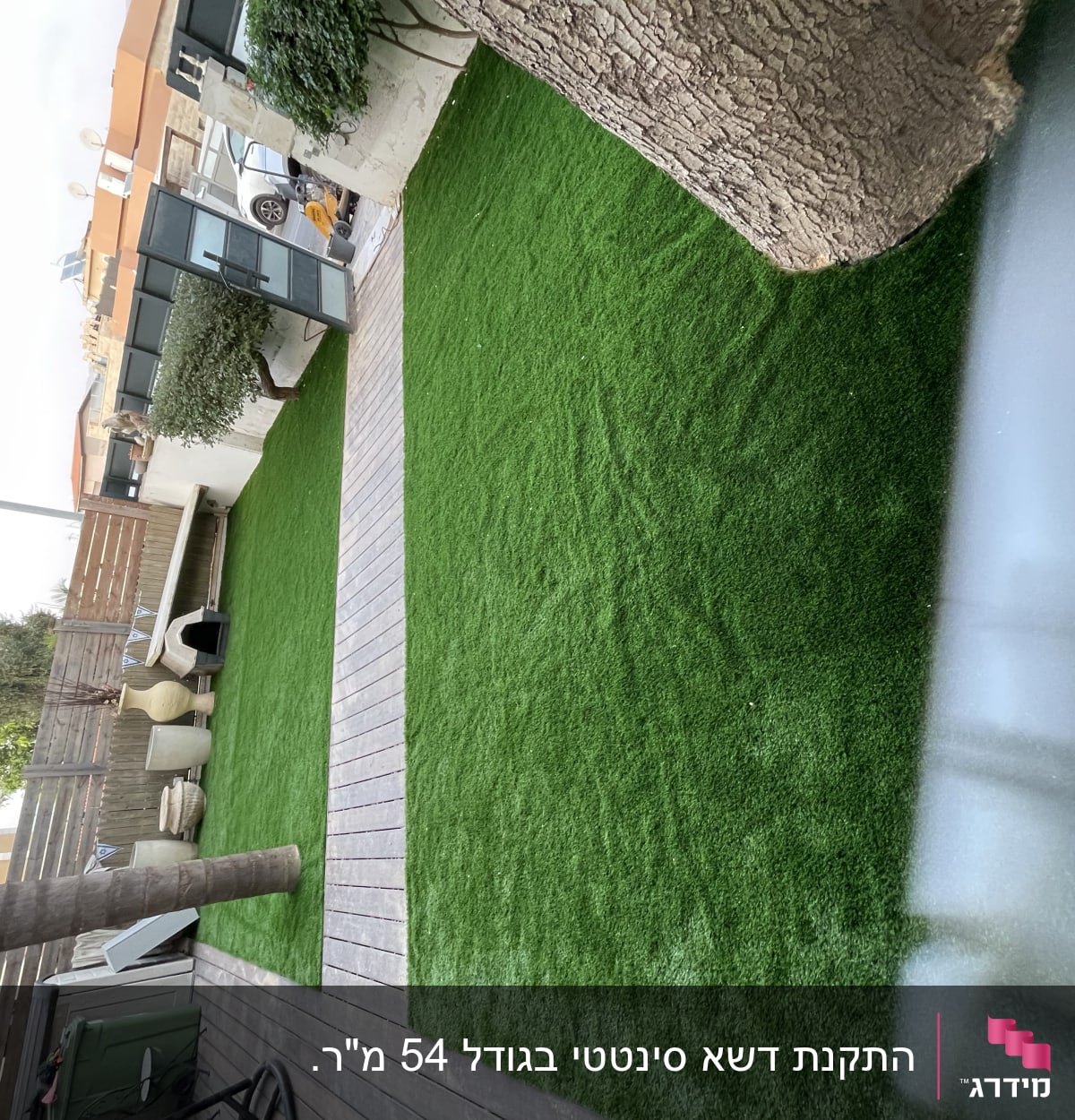 דשא סינתטי עם שביל עץ ועצים מסביב